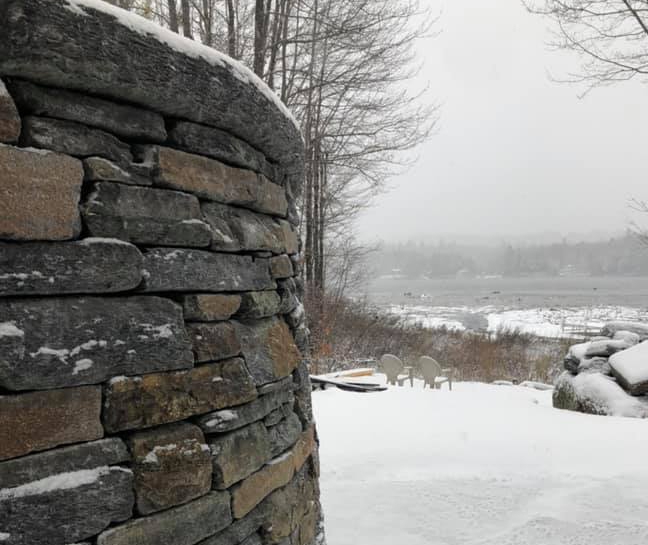 Curved stone wall on snowy hillside