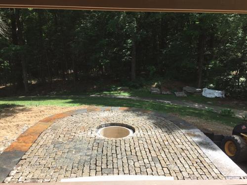raised cobblestone patio with fire pit or water fountain